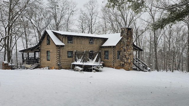 484 Buttermilk Rd, Blountville, TN 37617 - snow covered house featuring a trampoline, stairs, log siding, and a chimney