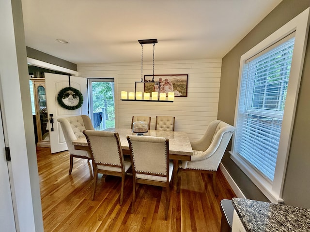2466 Kidwell Ridge Rd, Morristown, TN 37814 - dining area with dark wood-style floors, wooden walls, a chandelier, and baseboards