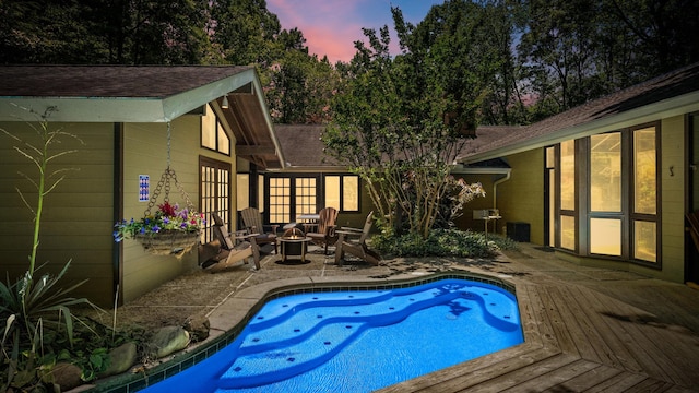 1115/1131 Old Cartertown Rd, Gatlinburg, TN 37738 - pool at dusk featuring a fire pit, a wooden deck, and an outdoor pool