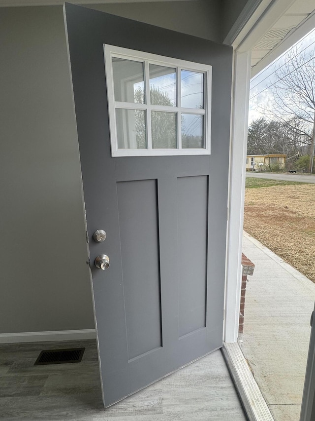 entryway with visible vents, baseboards, and wood finished floors