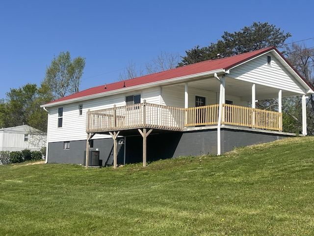 back of house featuring a yard, metal roof, and cooling unit