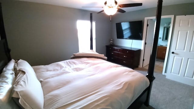 bedroom with light carpet, ensuite bath, and ceiling fan