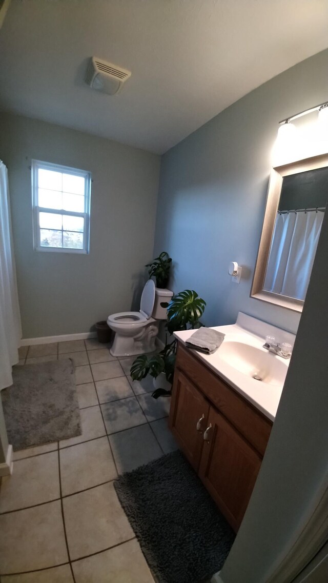 bathroom with tile patterned flooring, vanity, and toilet