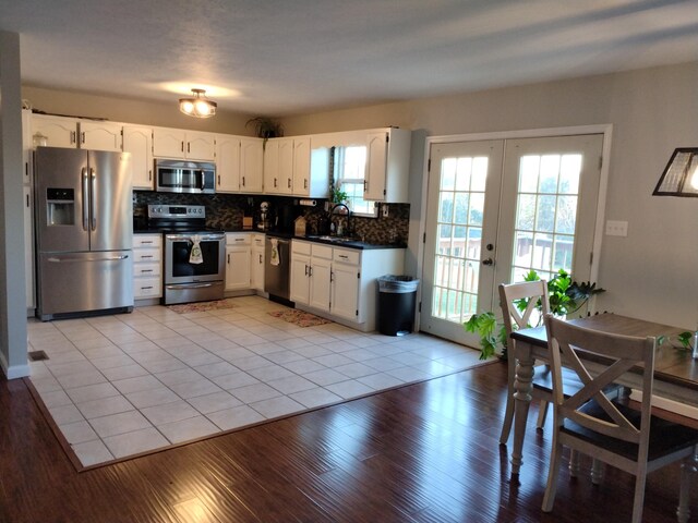 kitchen with french doors, white cabinets, sink, decorative backsplash, and appliances with stainless steel finishes