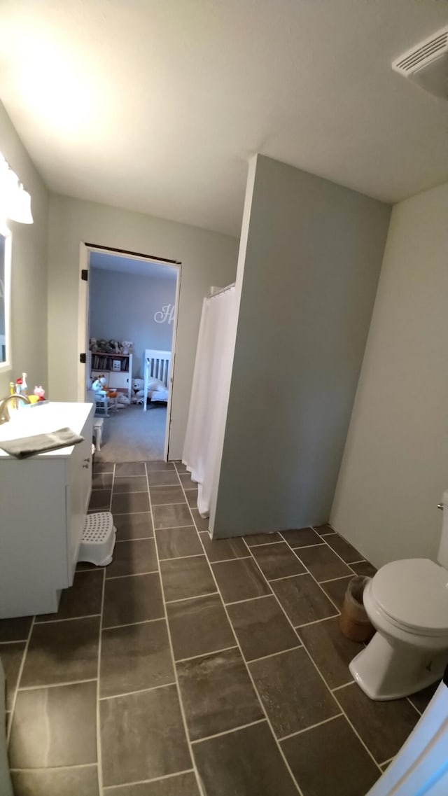 bathroom with tile patterned flooring, vanity, and toilet