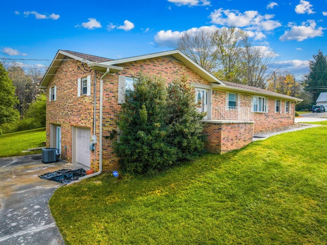 view of property exterior with a garage, a lawn, and central AC