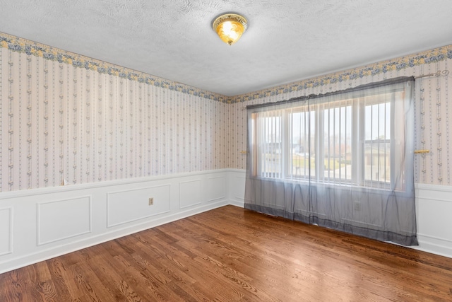 empty room featuring hardwood / wood-style flooring and a textured ceiling