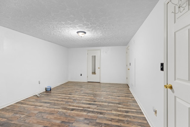 unfurnished room with dark hardwood / wood-style flooring and a textured ceiling