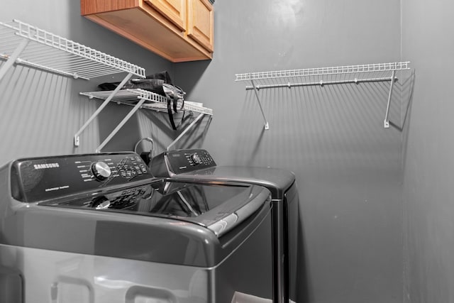 laundry room featuring cabinets and washer and clothes dryer