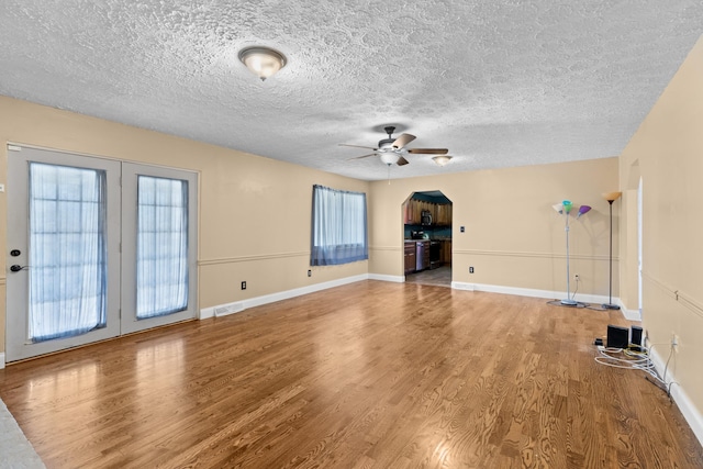 unfurnished living room with hardwood / wood-style floors, a healthy amount of sunlight, and ceiling fan