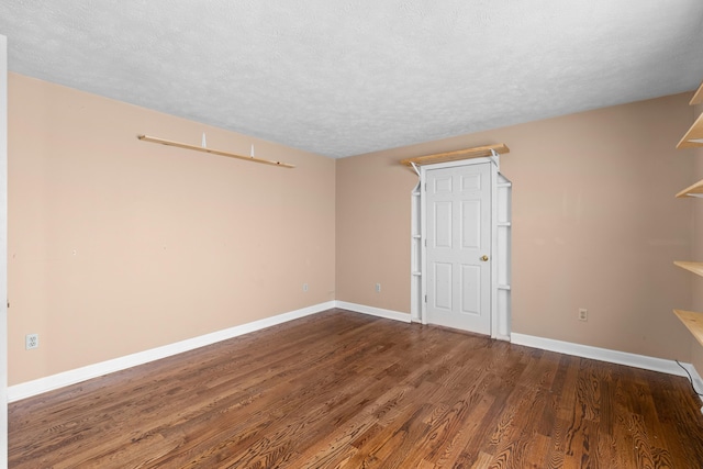 unfurnished room with dark hardwood / wood-style floors and a textured ceiling