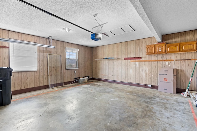 garage with a garage door opener and wood walls