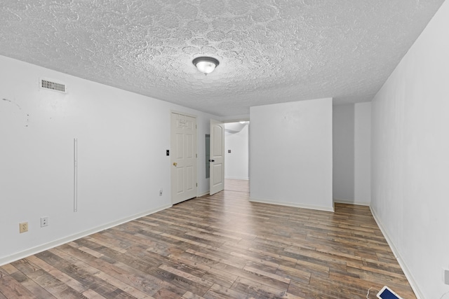 spare room with dark wood-type flooring and a textured ceiling