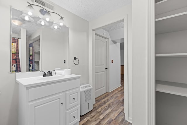 bathroom with vanity, wood-type flooring, and a textured ceiling