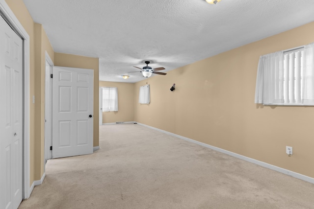 carpeted spare room with ceiling fan and a textured ceiling