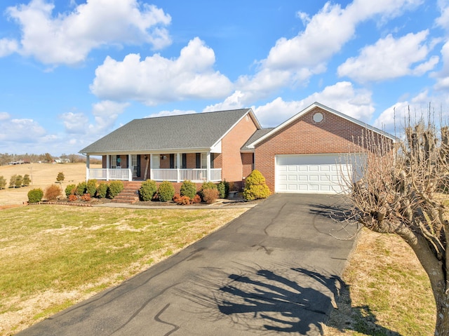 single story home with driveway, a porch, an attached garage, a front lawn, and brick siding