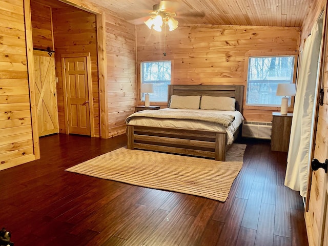 bedroom featuring ceiling fan, multiple windows, wooden walls, and wood ceiling