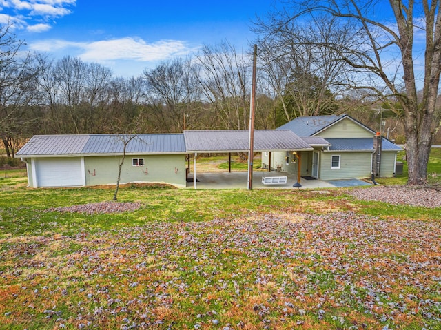 back of house with a garage and a yard