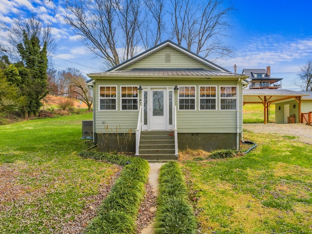 bungalow featuring a front lawn and central air condition unit