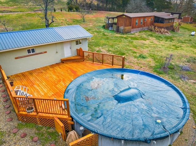 view of pool featuring a deck and a lawn