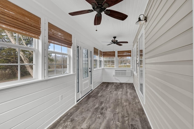 unfurnished sunroom featuring an AC wall unit and a wealth of natural light