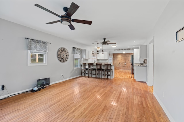 unfurnished living room with ceiling fan and light hardwood / wood-style floors