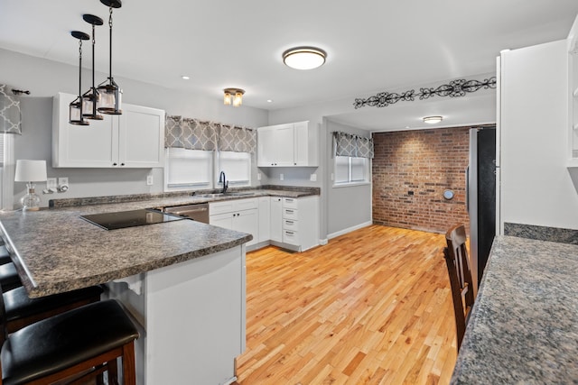 kitchen featuring appliances with stainless steel finishes, sink, white cabinets, and kitchen peninsula