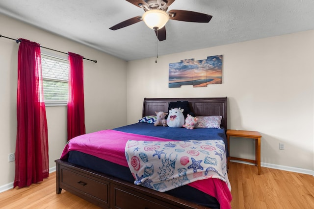 bedroom featuring a ceiling fan, baseboards, and wood finished floors