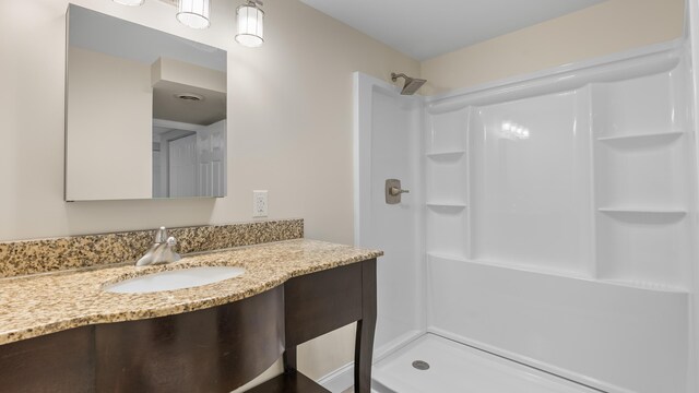 bathroom featuring a shower and vanity