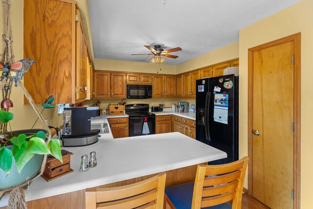 822 Osprey Dr, Morristown, TN 37814 - kitchen featuring black appliances, light countertops, a peninsula, a ceiling fan, and brown cabinets