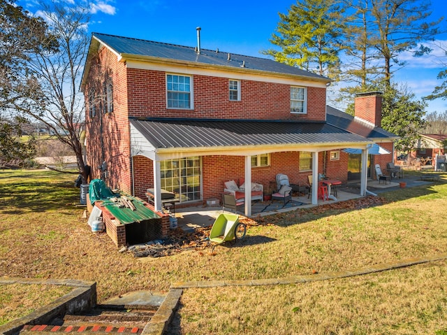 rear view of house with a lawn and a patio