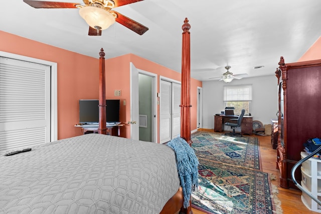 bedroom featuring ceiling fan, two closets, and light hardwood / wood-style floors