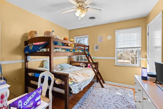 bedroom featuring wood-type flooring, multiple windows, and ceiling fan