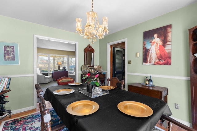 dining area featuring hardwood / wood-style flooring and a chandelier