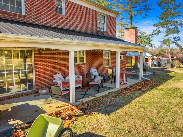 rear view of property featuring a patio area and a lawn