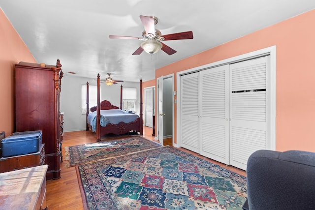 bedroom with light wood-type flooring, ceiling fan, and a closet