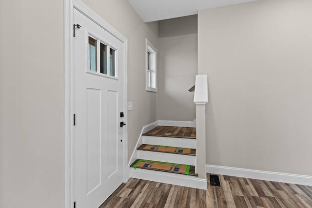 doorway to outside with baseboards and wood finished floors