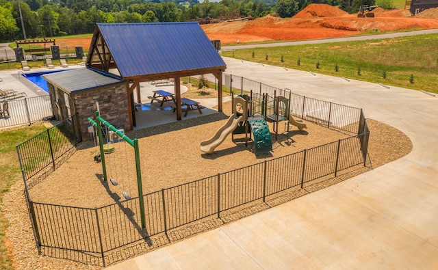 exterior space with a swimming pool, fence, and playground community