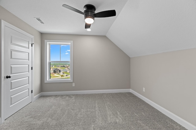 additional living space featuring carpet floors, visible vents, baseboards, ceiling fan, and vaulted ceiling
