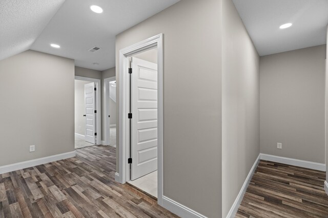 corridor featuring baseboards, recessed lighting, wood finished floors, and visible vents