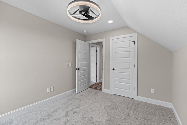 additional living space featuring carpet floors, baseboards, a ceiling fan, and vaulted ceiling