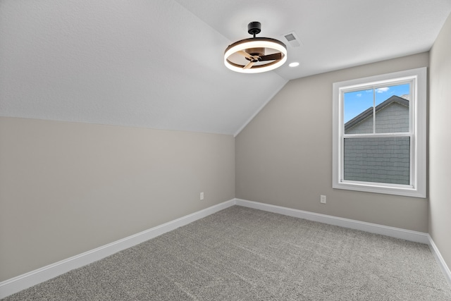 additional living space with visible vents, baseboards, carpet, and lofted ceiling