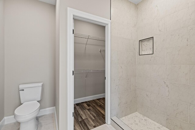 3183 Bridgewater Blvd, Morristown, TN 37814 - bathroom with baseboards, a tile shower, toilet, and a spacious closet
