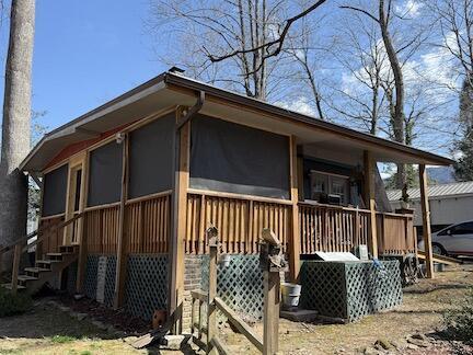 view of side of property featuring a sunroom and stairs