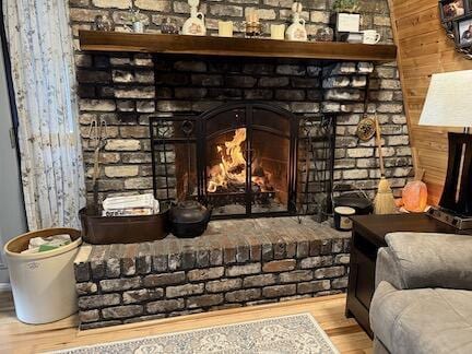 room details featuring a brick fireplace and wood finished floors