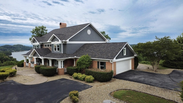 1564 Tranquility Trl, Dandridge, TN 37725 - view of front of property featuring covered porch, a chimney, driveway, a garage, and roof with shingles