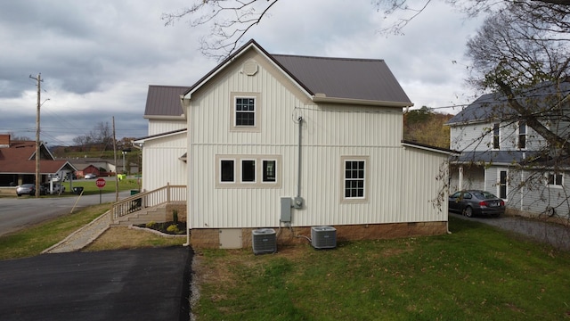 rear view of house with a yard and central AC