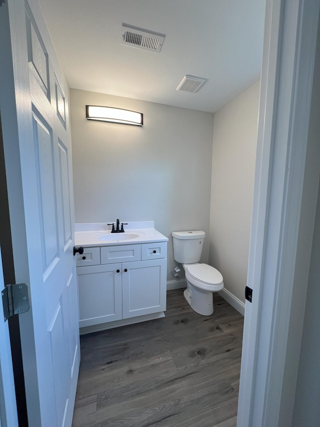 bathroom with vanity, wood-type flooring, and toilet