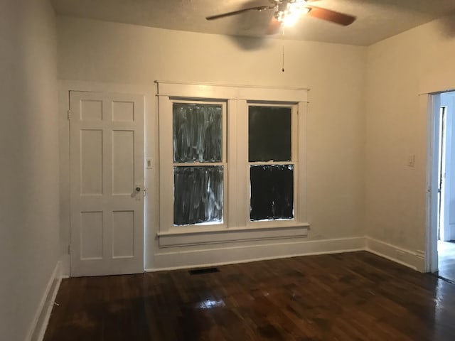 foyer entrance with ceiling fan and dark wood-type flooring