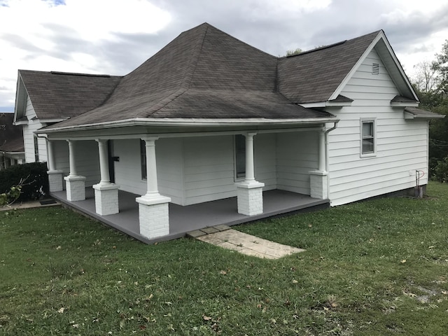 view of home's exterior featuring a lawn and covered porch